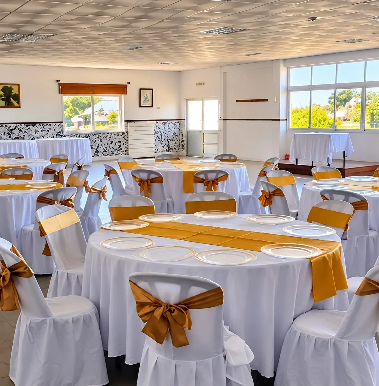 Sala com mesas redondas e laços dourados